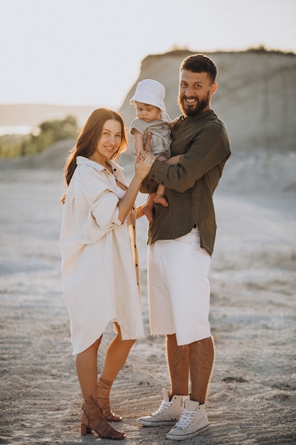 Jeune famille avec petit fils au coucher du soleil