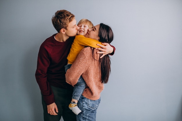 Jeune famille avec petit fils ensemble sur gris