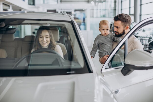 Jeune famille avec petite fille choisissant une voiture