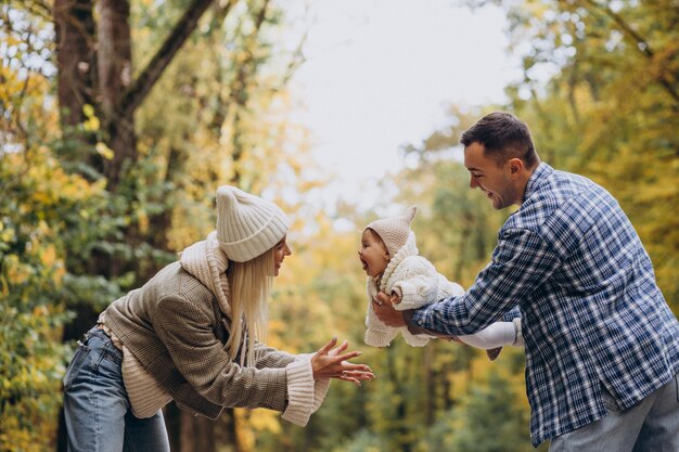 Jeune famille avec petite fille dans le parc d'automne