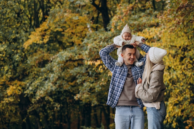 Jeune famille avec petite fille dans le parc d'automne