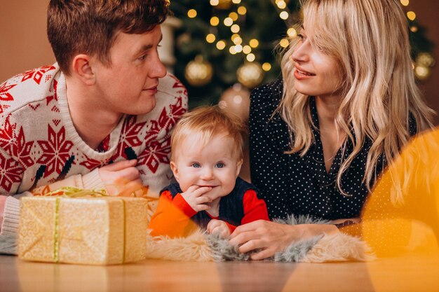 Jeune famille avec petite fille tenant des cadeaux de Noël