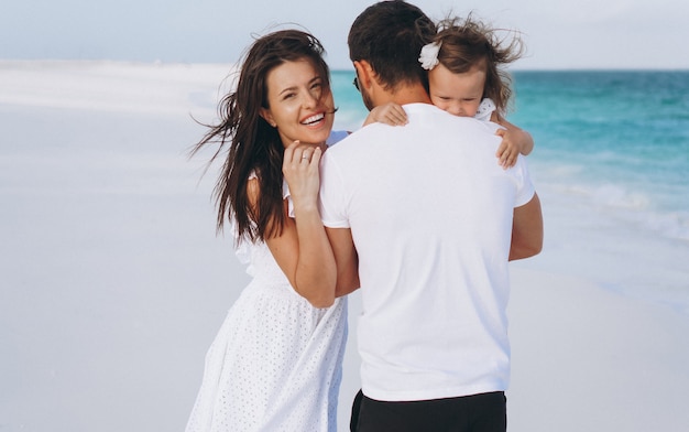 Jeune famille avec petite fille en vacances au bord de l'océan