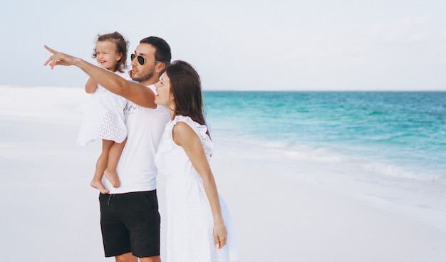 Jeune famille avec petite fille en vacances au bord de l'océan