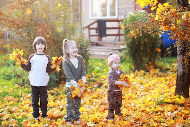 Jeune famille en promenade dans le parc en automne par une journée ensoleillée. le bonheur d'être ensemble.