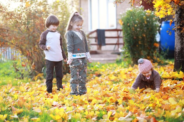 Jeune famille en promenade dans le parc en automne par une journée ensoleillée. le bonheur d'être ensemble.