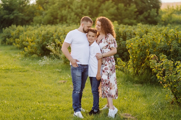 Jeune famille à la recherche en marchant dans le jardin