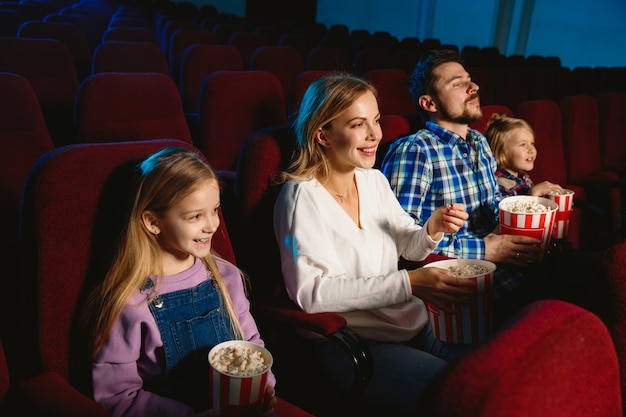 Jeune famille regardant un film dans un cinéma