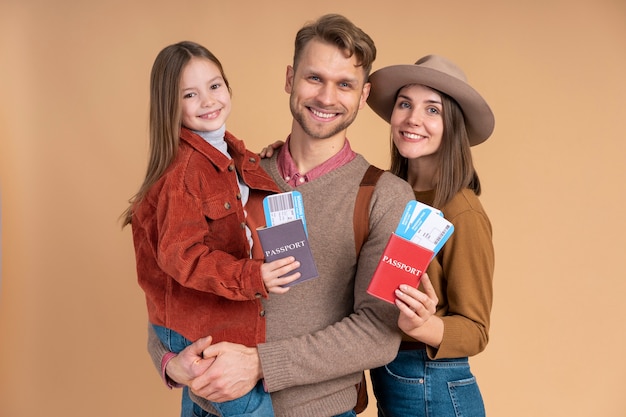 Jeune famille de trois personnes posant ensemble avant les vacances de voyage