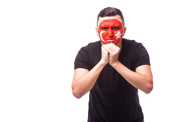 Jeune fan de football homme tunisie avec geste de prière isolé sur mur blanc