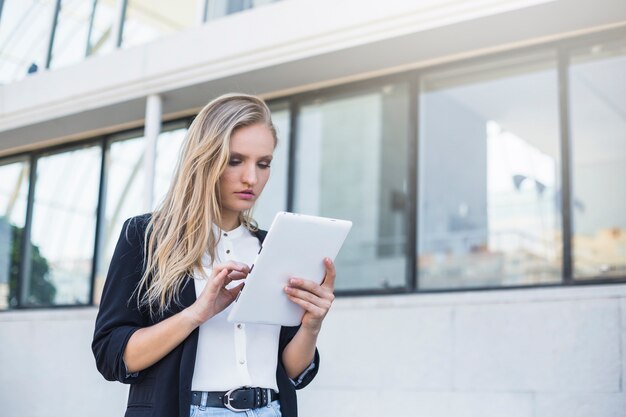 Jeune femme d&#39;affaires à l&#39;aide de tablette numérique