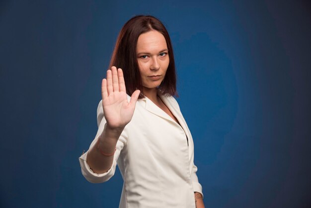 Jeune femme d'affaires en blazer blanc disant au revoir.