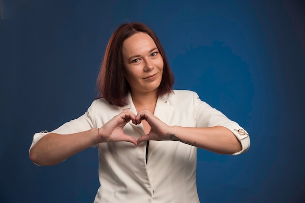 Photo gratuite jeune femme d'affaires en blazer blanc envoi d'amour.