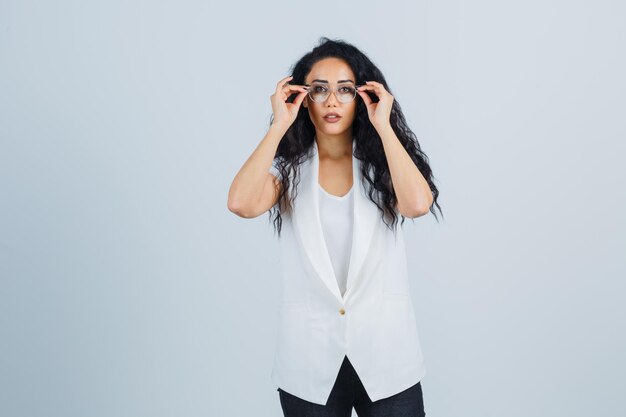 Jeune femme d'affaires dans une veste blanche avec des lunettes