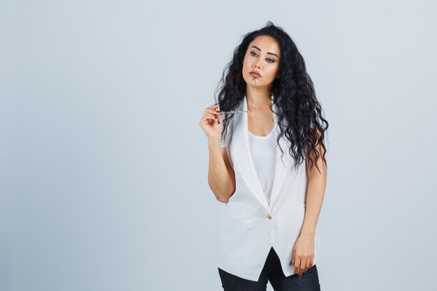 Jeune femme d'affaires dans une veste blanche avec des lunettes