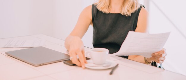 Jeune, femme affaires, document, papier, main, tenue, tasse café, lieu de travail