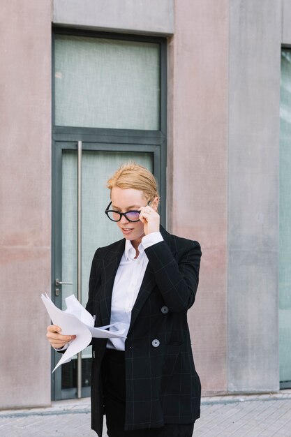 Jeune, femme affaires, à, lunettes lunettes, regarder, documents