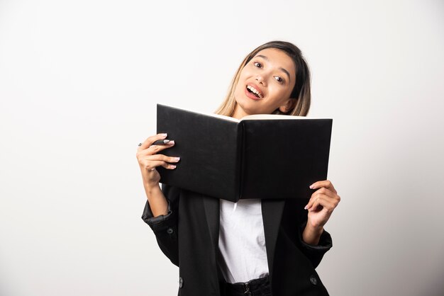 Jeune femme d'affaires montrant un presse-papiers noir.