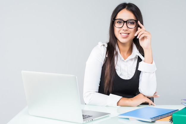 Jeune femme d'affaires avec ordinateur portable au bureau isolé sur blanc