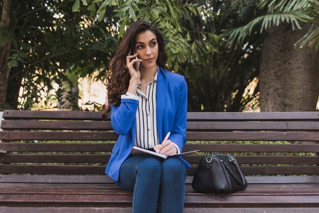 Jeune femme d&#39;affaires pensant tout en parlant au téléphone