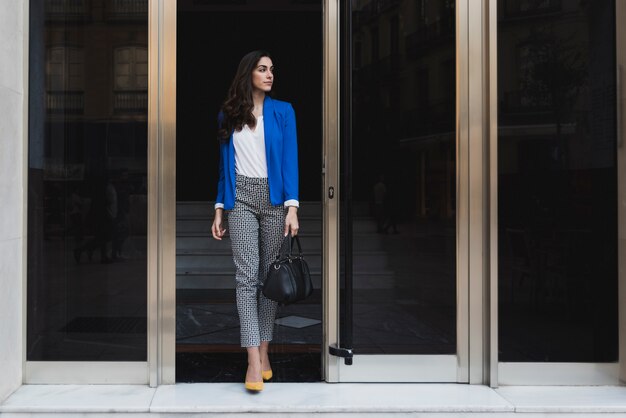 Jeune femme d&#39;affaires posant avec son sac à main