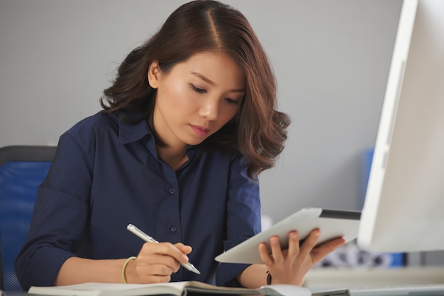 Jeune femme d'affaires prenant des notes