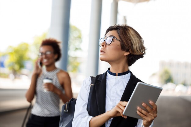 Jeune femme d'affaires réussie tenant la tablette sur le centre d'affaires.