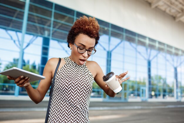 Jeune femme d'affaires réussie trempée de café debout près du centre d'affaires.