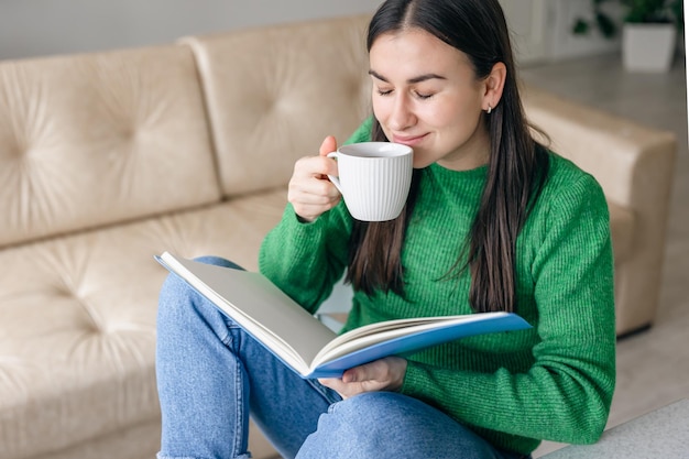 Jeune femme d'affaires avec une tasse de café avec un bloc-notes à la maison