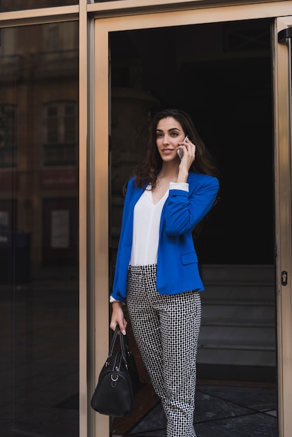 Jeune femme d&#39;affaires avec un téléphone mobile et sac à main