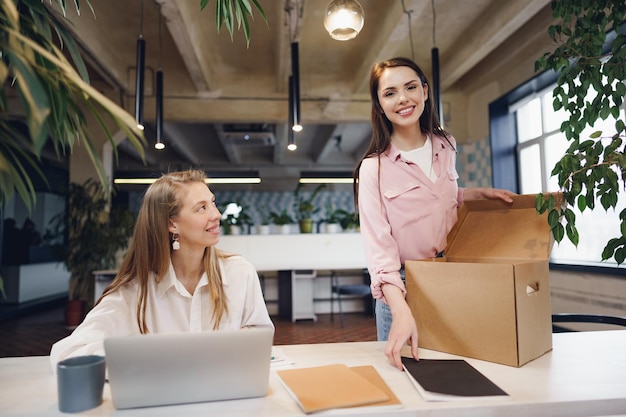 Jeune femme d'affaires tenant une boîte d'effets personnels sur le point de quitter ses fonctions après avoir quitté son emploi