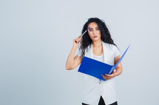 Jeune femme d'affaires tenant un dossier bleu