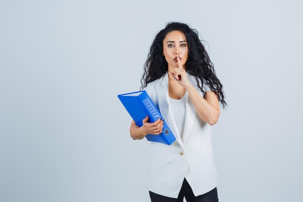 Jeune femme d'affaires tenant un dossier bleu