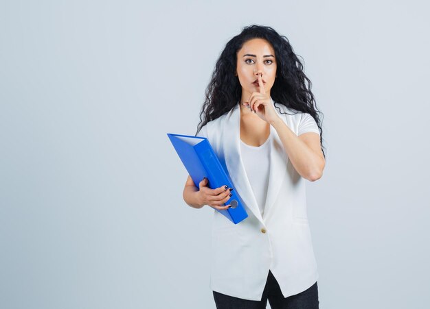 Jeune femme d'affaires tenant un dossier bleu