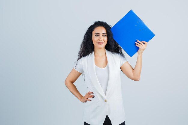 Jeune femme d'affaires tenant un dossier bleu