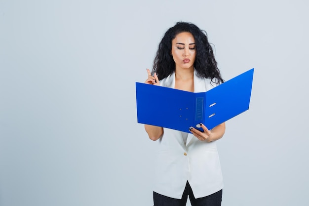 Jeune femme d'affaires tenant un dossier bleu