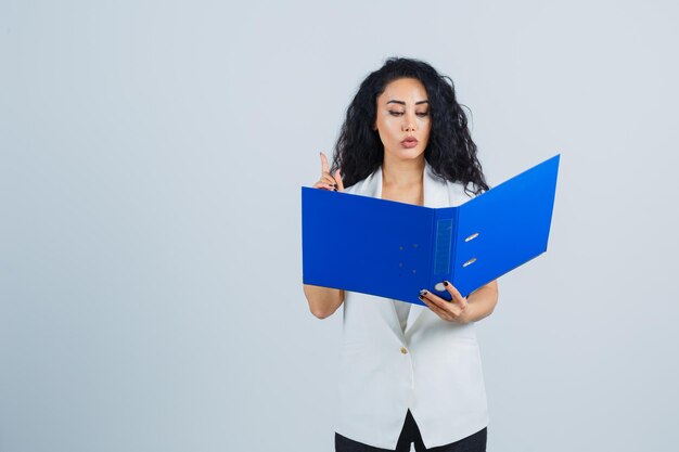 Jeune femme d'affaires tenant un dossier bleu