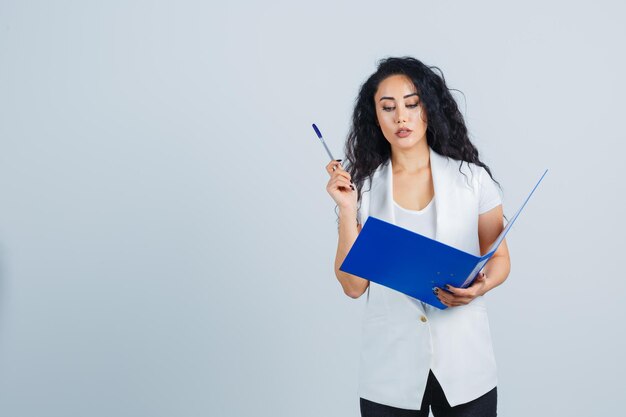 Jeune femme d'affaires tenant un dossier bleu