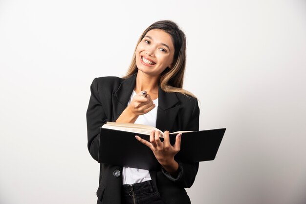 Jeune femme d'affaires tenant le presse-papiers avec un crayon.