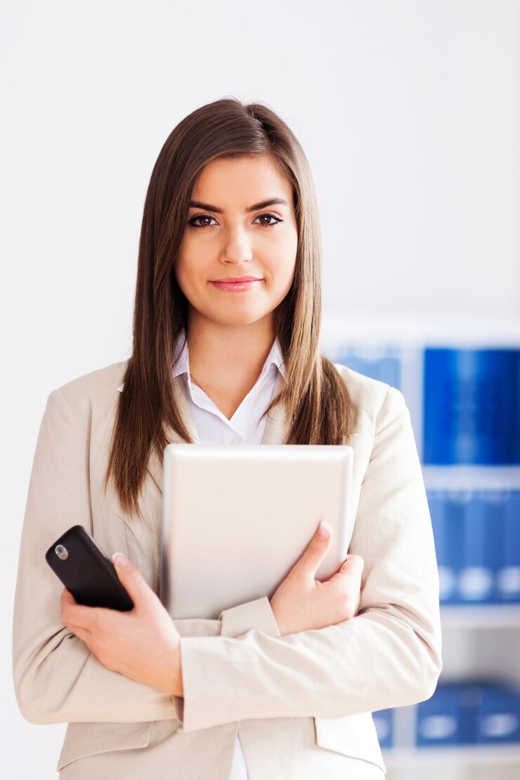 Photo gratuit jeune femme d'affaires tenant une tablette numérique et un téléphone mobile