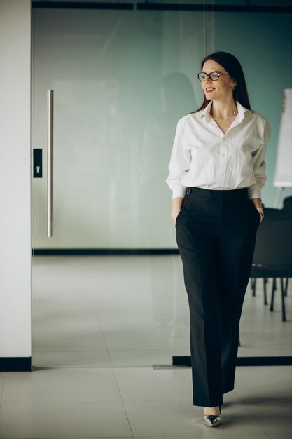 Jeune femme d'affaires en tenue de soirée debout au bureau