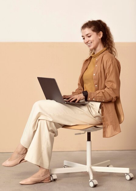 Jeune femme d'affaires travaillant à l'intérieur depuis un ordinateur portable