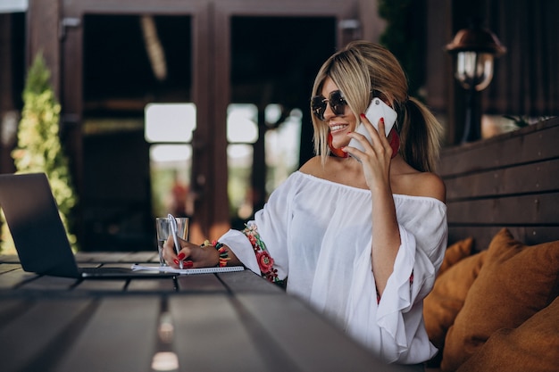 Jeune femme d'affaires travaillant sur ordinateur au bar