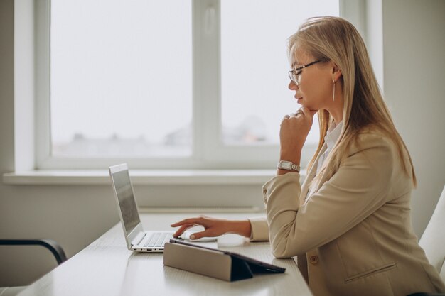 Jeune femme d'affaires travaillant sur ordinateur au bureau