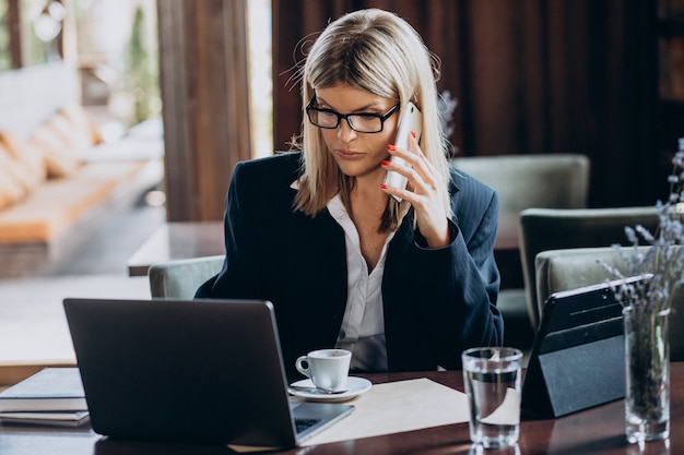 Jeune femme d'affaires travaillant sur ordinateur dans un café