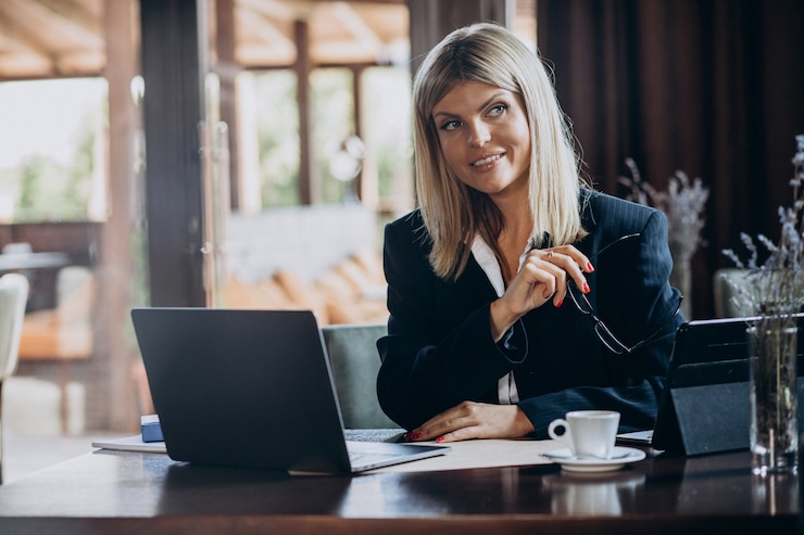 Photo gratuit jeune femme d'affaires travaillant sur ordinateur dans un café