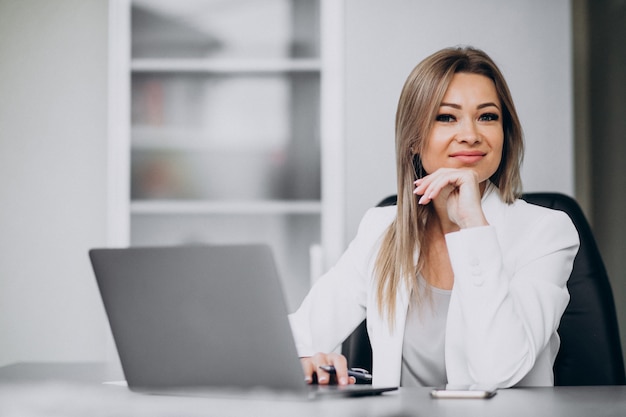 Jeune femme d'affaires travaillant sur ordinateur portable dans un bureau