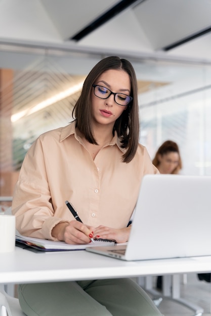 Jeune femme d'affaires travaillant à son bureau avec ordinateur portable