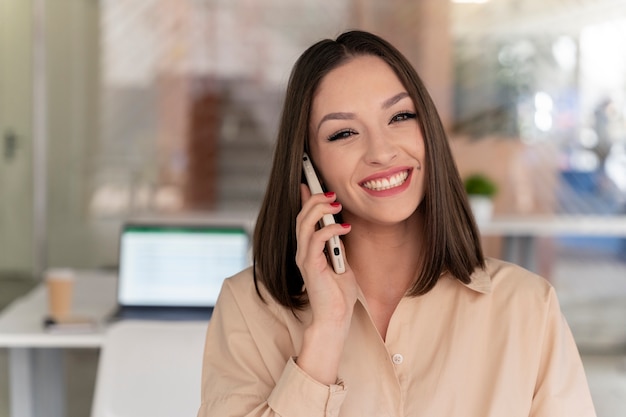 Jeune femme d'affaires travaillant à son bureau avec smartphone