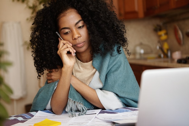 Jeune femme africaine déprimée incapable de payer les factures de gaz et d'électricité en parlant au téléphone portable, mécontente de la décision de la banque de ne pas prolonger la durée du prêt. Problème financier et crise économique